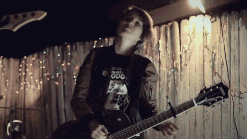 a person playing a guitar with a shirt on that says odd