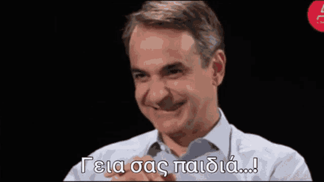 a man in a white shirt is smiling with a foreign language written on the bottom of his face .