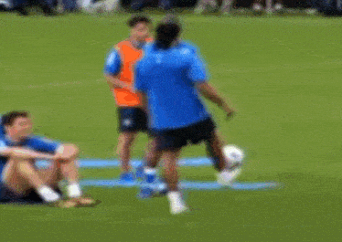 a blurry picture of soccer players on a field with one wearing a shirt that says ' allianz ' on it