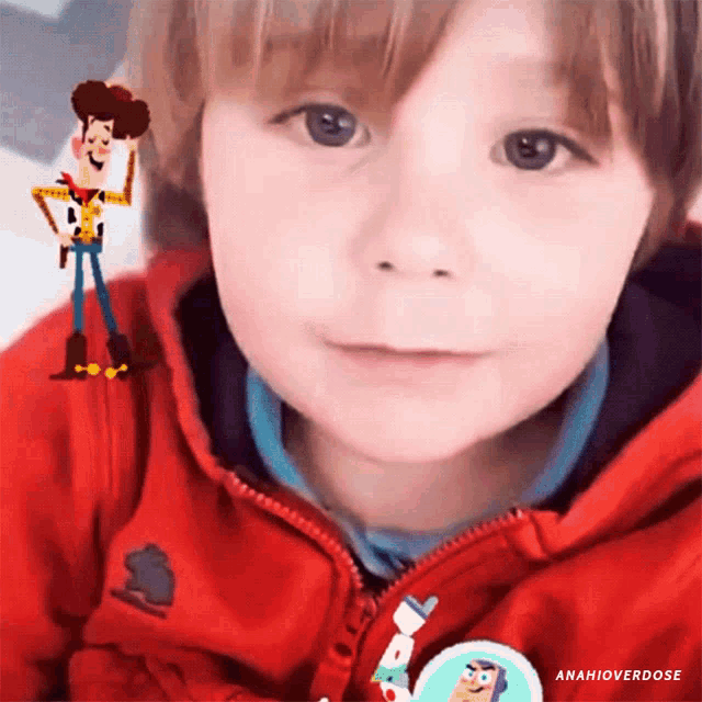a young boy wearing a red jacket has a toy story woody sticker on his chest