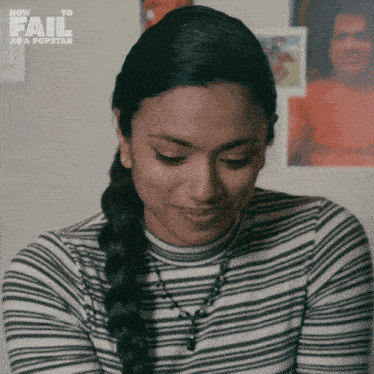 a woman wearing a striped shirt with the words how to fail as a popstar on the top