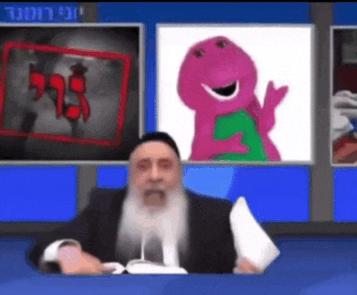 a man with a beard is sitting in front of a television with a picture of barney on the screen .