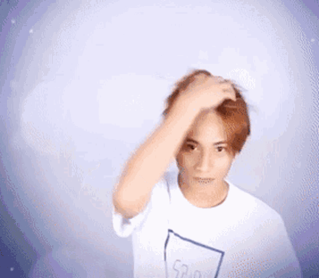 a young man wearing a white shirt with the word sup written on it