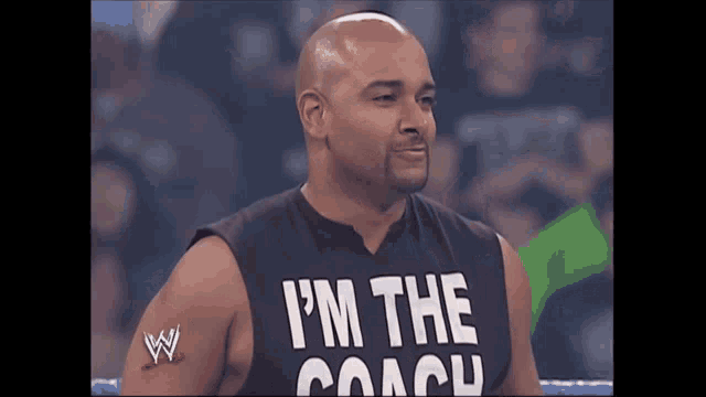 a bald man wearing a black shirt that says i 'm the coach