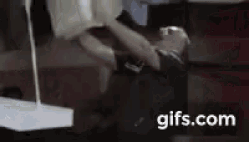 a man in a black shirt is standing in front of a gifs.com banner
