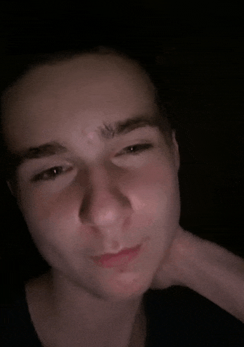 a close up of a young man 's face with a black background .