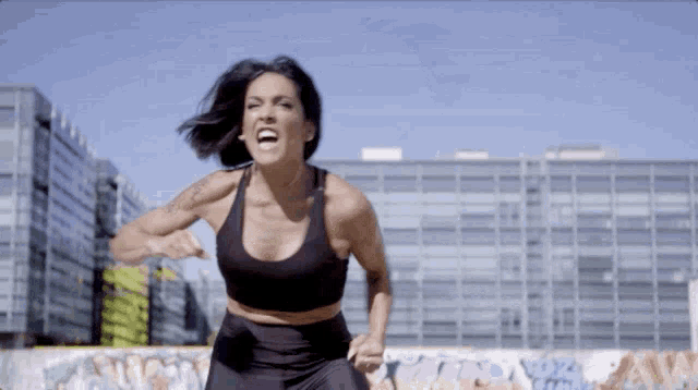 a woman with a tattoo on her arm is running