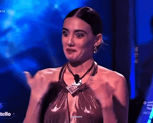 a woman in a metallic dress is making a funny face on a television show