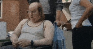 a man in a wheelchair is talking to a woman in a blue shirt