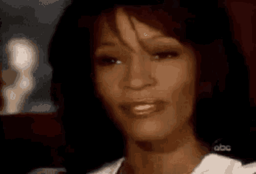 a close up of a woman 's face with a smile on her face and a blurred background .