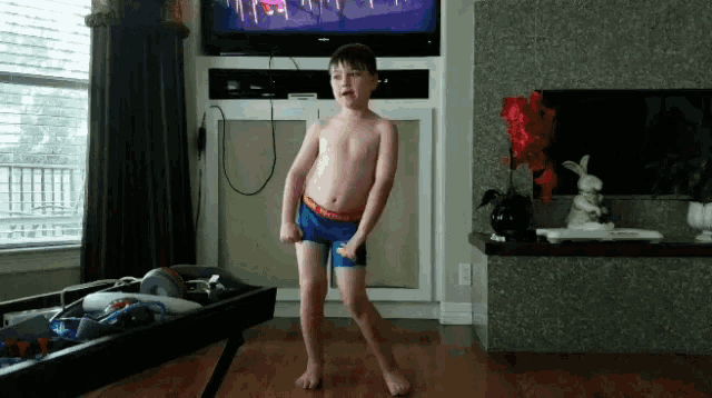 a young boy is dancing in front of a television