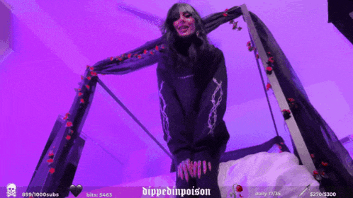 a woman in a black sweater stands in front of a purple background that says dippedinpoison