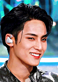a close up of a man wearing ear buds and smiling