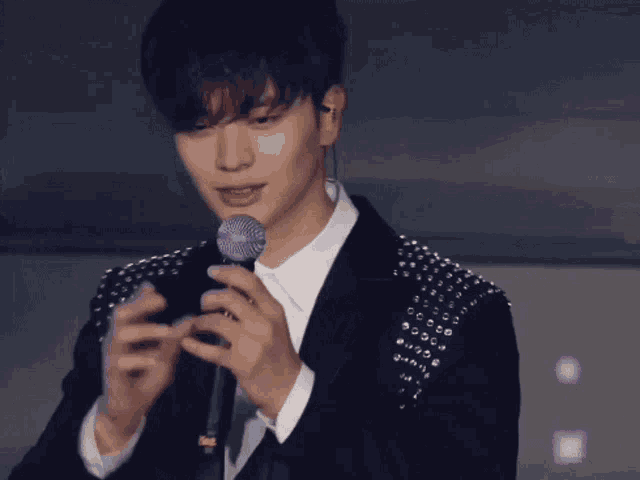 a man in a suit is holding a microphone
