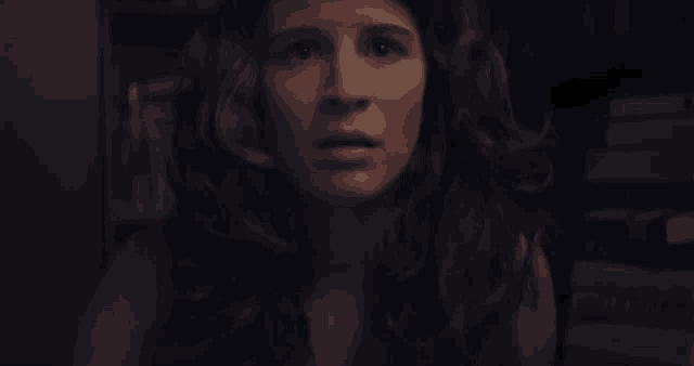 a close up of a woman 's face in a dark room