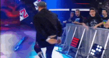 a man is walking on a stage in front of a crowd of people .