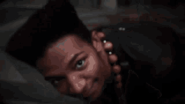 a man is holding a bunch of money in his hand in a dark room .