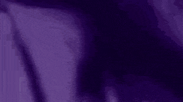 a close up of a person wearing headphones in a purple light .