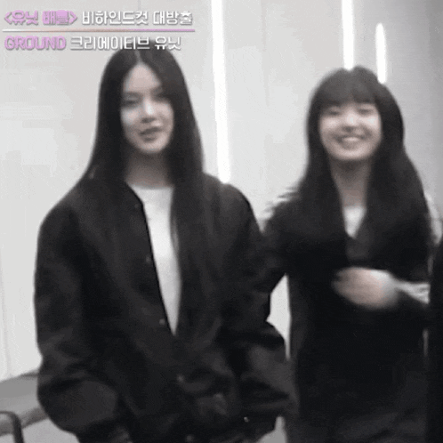 two young women are standing next to each other in a room .