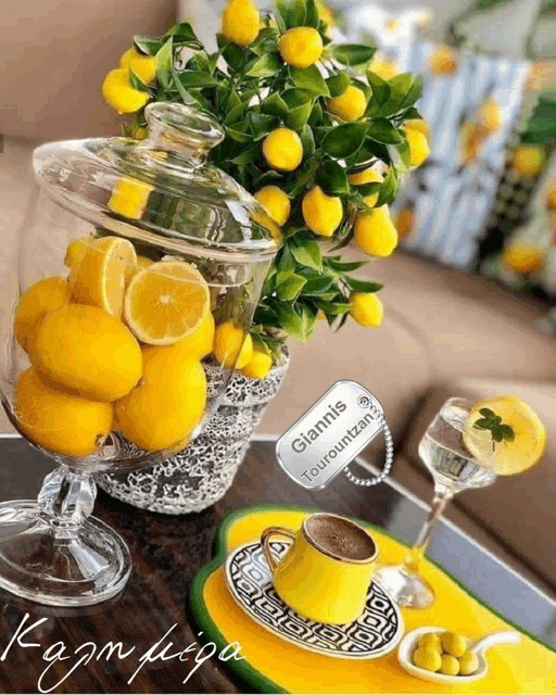 a cup of coffee sits next to a vase of lemons