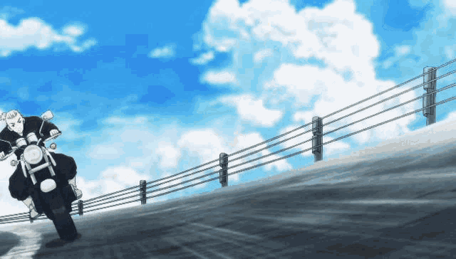 a man is riding a motorcycle down a road with a fence in the background