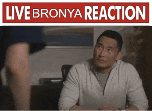 a man sits at a table with a live bronya reaction sign above him