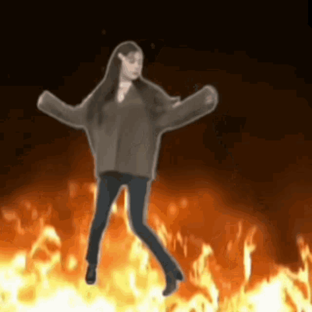 a woman is dancing in front of a fire .