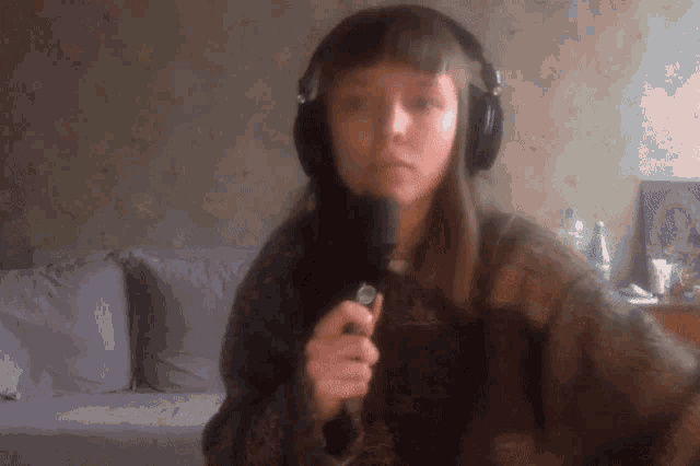 a girl wearing headphones is holding a microphone