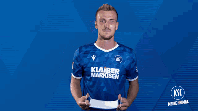 a man wearing a blue shirt that says klaber markisen on it