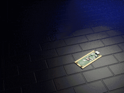 a green and gold electronic device is laying on a black brick floor