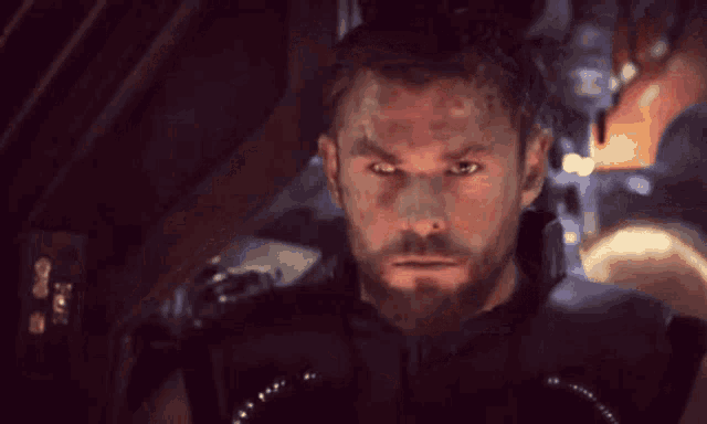 a man with a beard looks at the camera