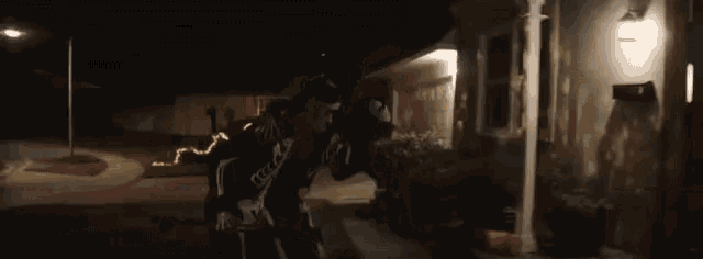 a man in a skeleton costume is standing in front of a door .