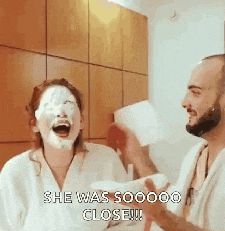 a man is giving a woman a face mask while she is laughing .