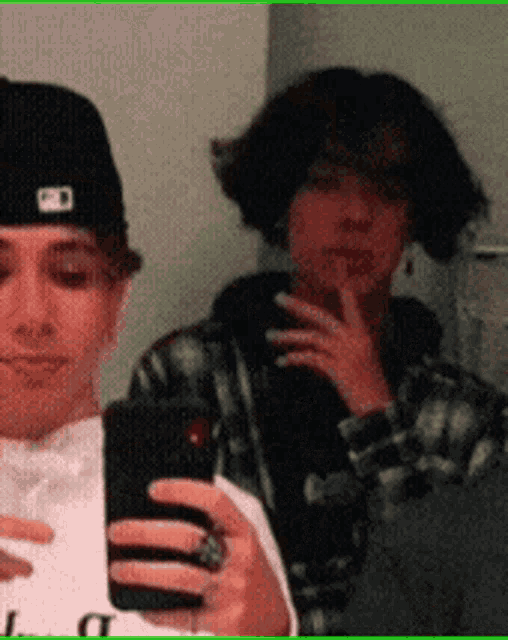two people are taking a picture of themselves in a bathroom mirror