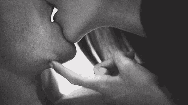 a black and white photo of a man and woman kissing
