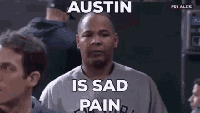 a man in a baseball uniform is crying while watching a baseball game and a meme says austin is sad pain .