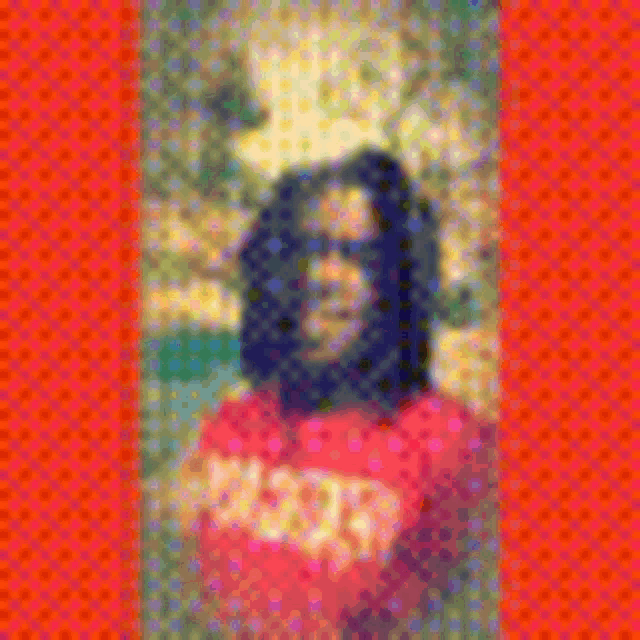 a blurry picture of a man with long hair wearing a red shirt with the letter a on it .