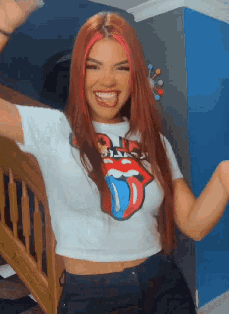 a woman wearing a rolling stones shirt is smiling