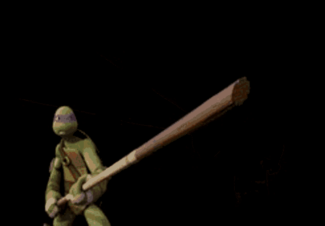 a teenage mutant ninja turtle is jumping through a hole in a dark room .