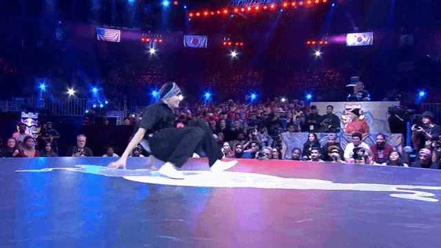 a man is doing a trick on a stage in front of a crowd of people