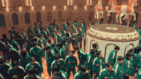 a large group of people are standing around a carousel with horses