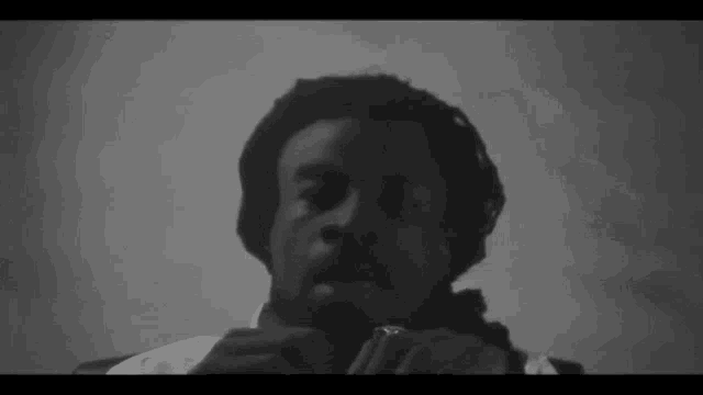 a black and white photo of a man wearing headphones and a beanie .