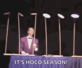 a man is standing in front of a table with plates on it and a sign that says it 's hoco season .