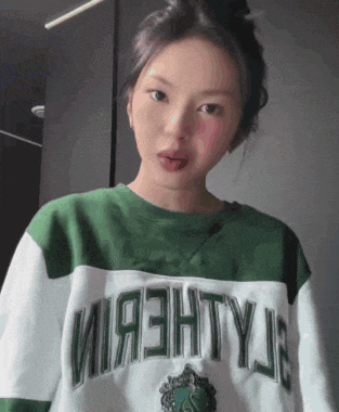 a woman wearing a green and white sweater that says mighty e on it