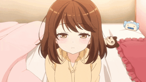 a girl with brown hair is sitting on a bed next to a stuffed animal and a blue alarm clock