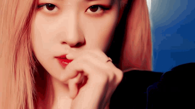 a close up of a woman 's face with a ring on her finger