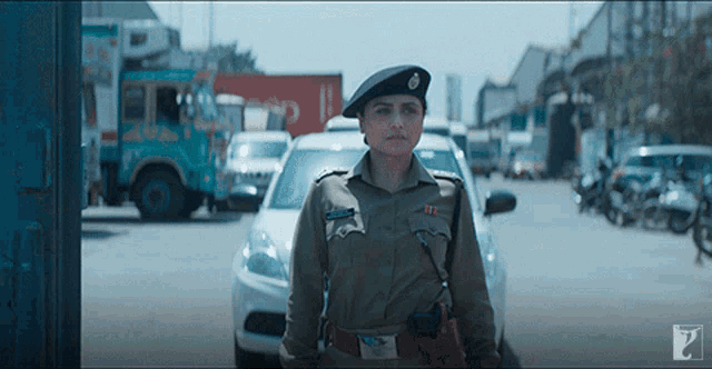 a woman in a police uniform is standing in front of a busy street