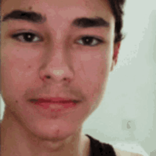 a close up of a young man 's face with a beard