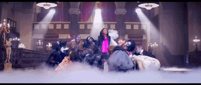 a woman in a pink jacket is surrounded by zombies in a room