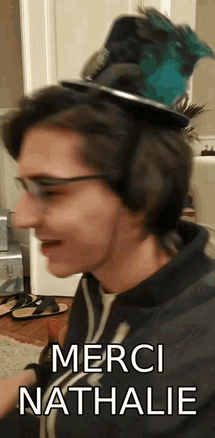 a man wearing glasses and a top hat with the words merci nathalie above him